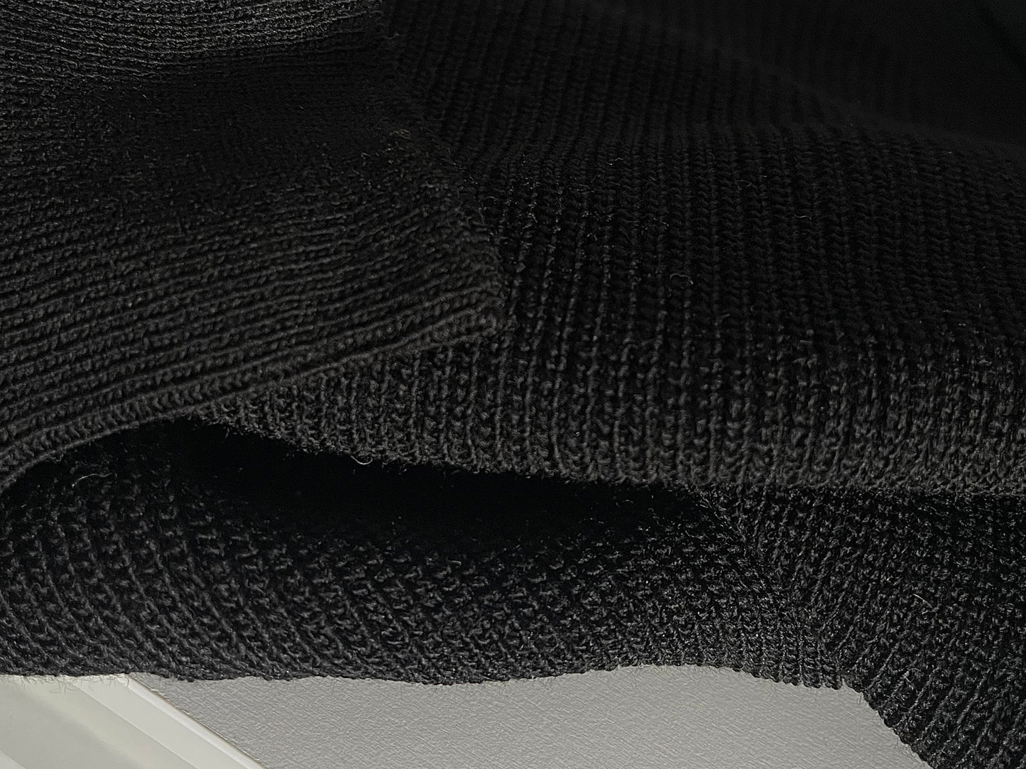 Schwarzer Pullover mit goldenem Knopf