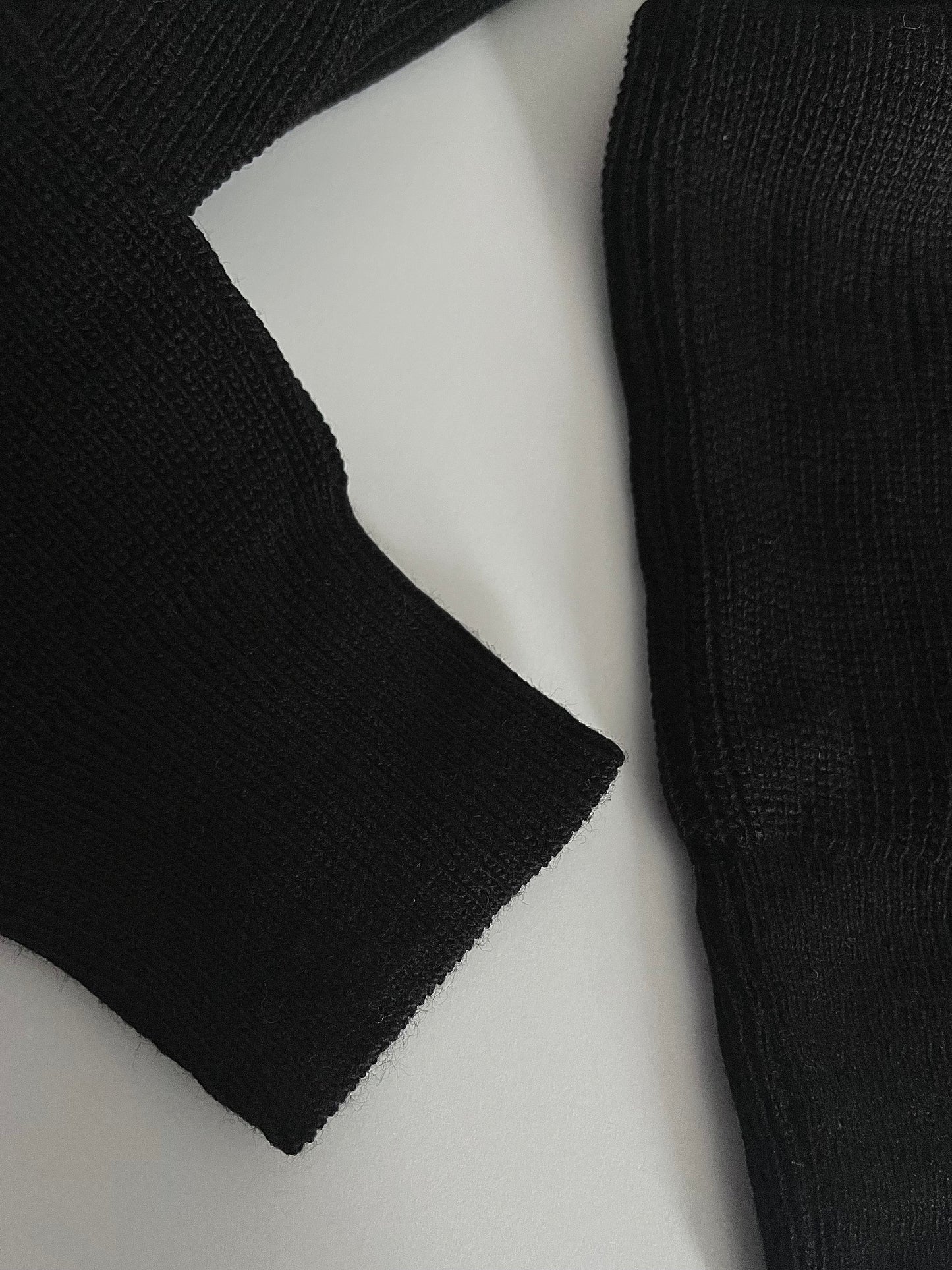Schwarzer Pullover mit goldenem Knopf