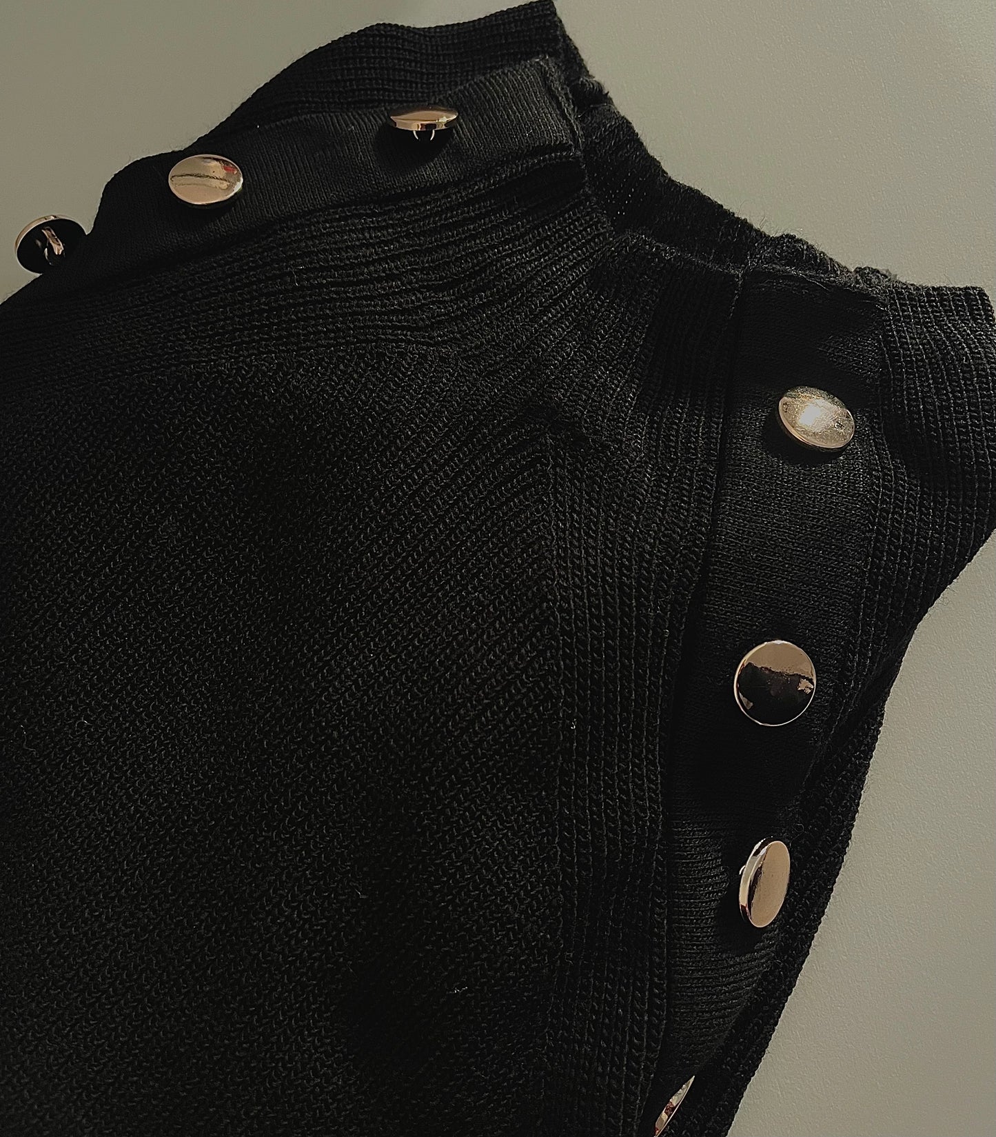 Schwarzer Pullover mit goldenem Knopf